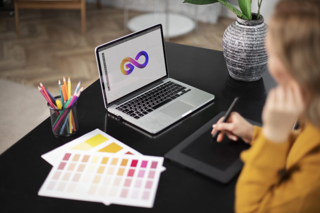 Graphic designer al lavoro su tablet e laptop per la progettazione di roll up pubblicitari